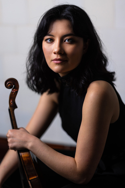 Gabrielle Després stares into the camera holding her violin by the neck.