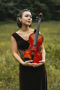 Laura Liu stands cradling her viola in her arms.