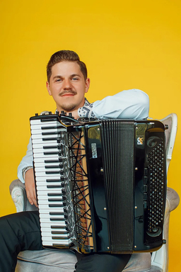 Radu Ratoi sits holding his accordian.